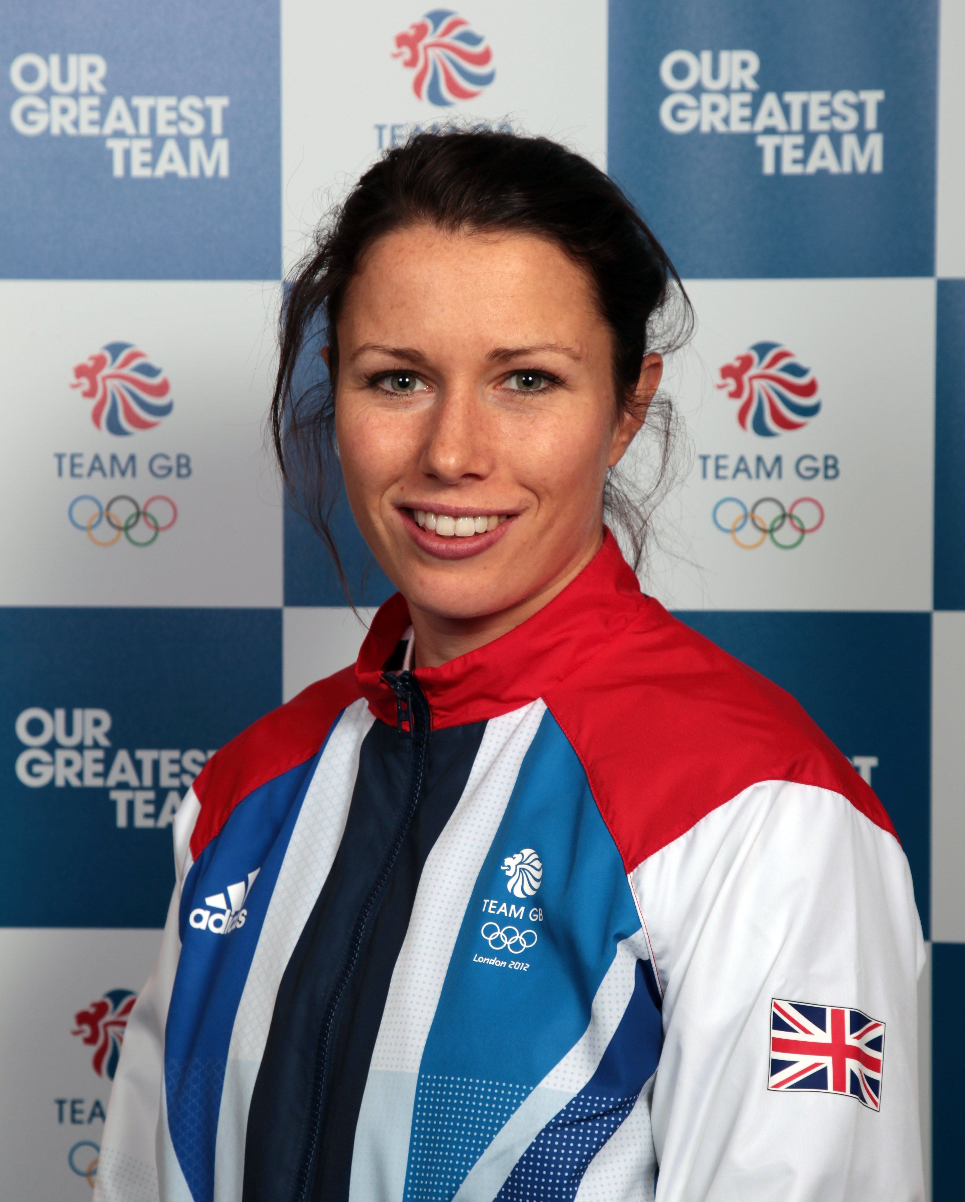 Headshot of Annie Panter. A white woman with dark hair, smiling. Dressed in Team GB kit.