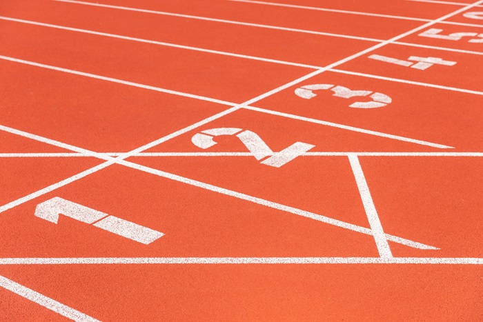 An athletics track finish link showing the lane numbers written on the floor from one to five.
