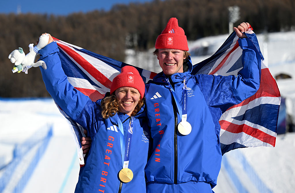 Gold medalists Charlotte Bankes and Huw Nightingale of Team Great Britain pose for a photo whilst wearing the national flag of Great Britain.
