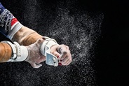 Close-up of gymnast hands with chalk before competition.