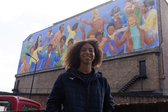 Darcy standing in front a mural in Brixton