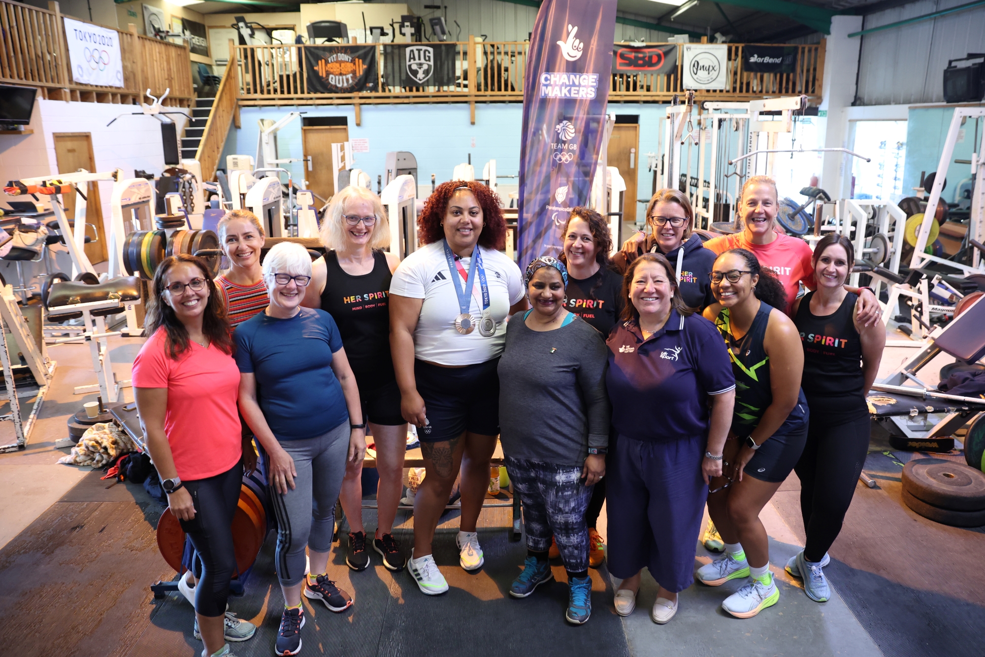Team GB Weightlifter Emily Campbell who is passionate about inspiring women and girls into physical activity poses for a picture in a gym with attendees to launch ChangeMakers.