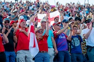 Group of England Hockey supported stood in a crowd, cheering and waving flags