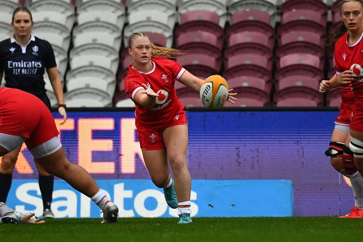 Welsh player Seren, twists her body to the side as she throws a rugby balls to a team mate.