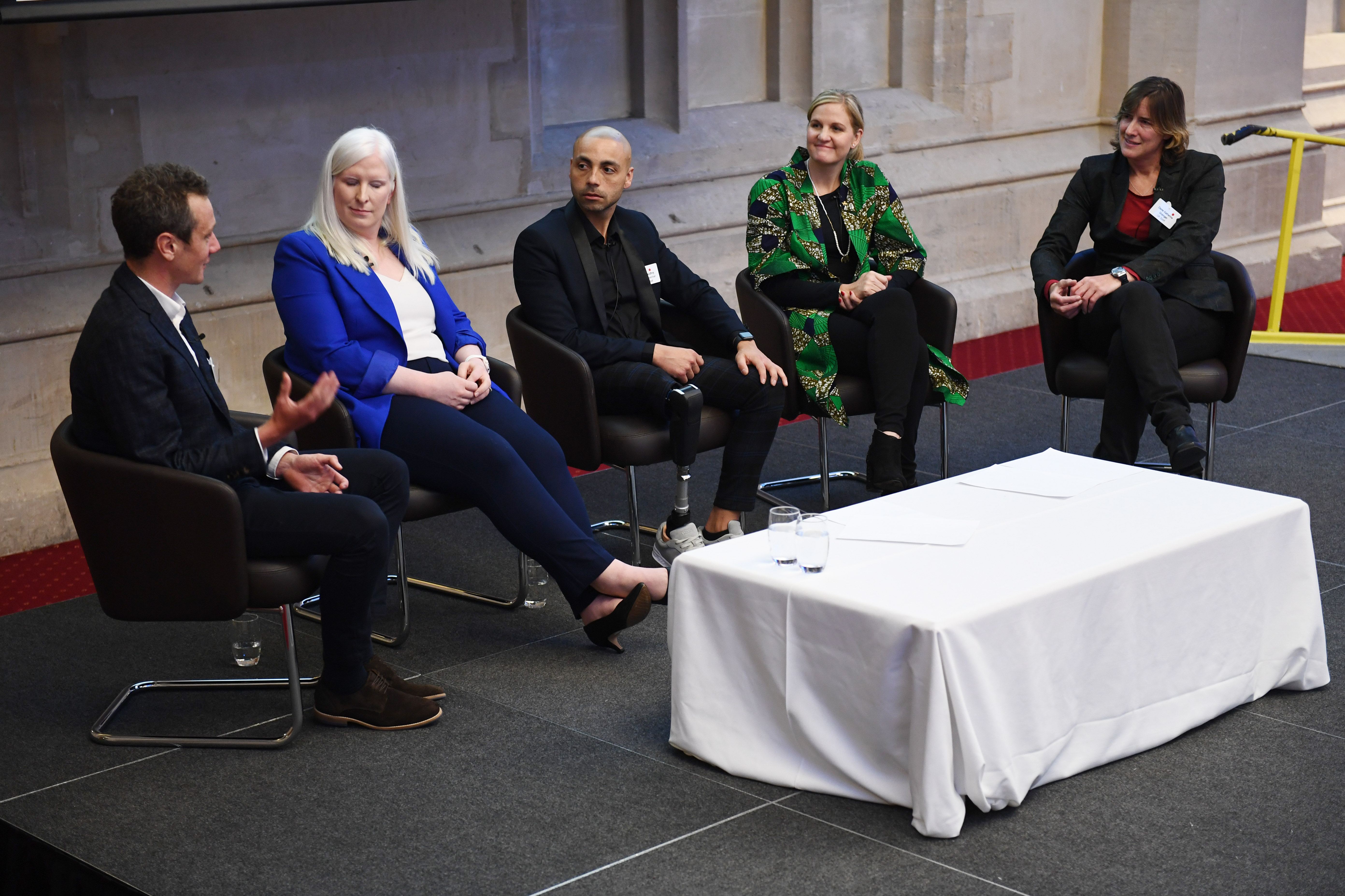 five athletes sat on stage in mid disussion