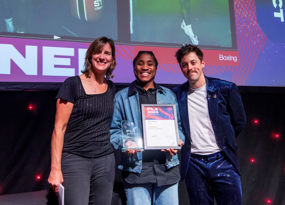 Condy Ngbambe stands on the stage poses with her award alongside Katherine Grainger and Blaine Hunt PLY the hosts.