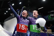 Two athletes for Team Great Britain acknowledge the fans after winning the gold medals.