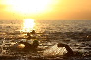 sunrise whilst swimmers swim in the sea on the coast of Britian 