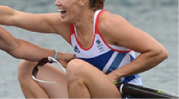 Helen Glover, a female Team GB athlete. Sat in a rowing boat smiling and celebrating