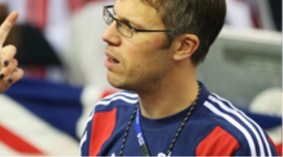 Team GB coach, Paul Manning. White man with short brown hair, wearing glasses and Team GB kit