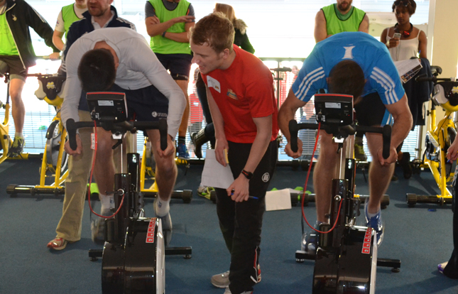 Two people undertaking performance testing on static bikes