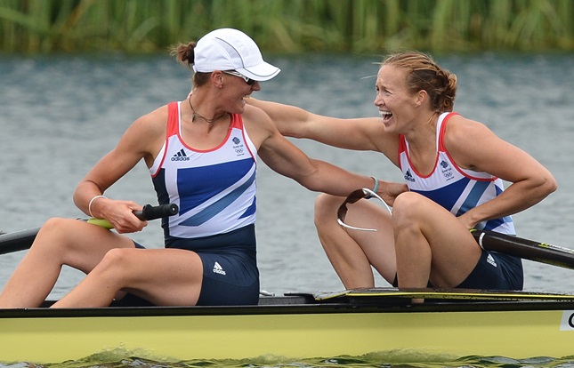 Two Team GB athletes in a rowing boat. Smiling and congratulating each other.