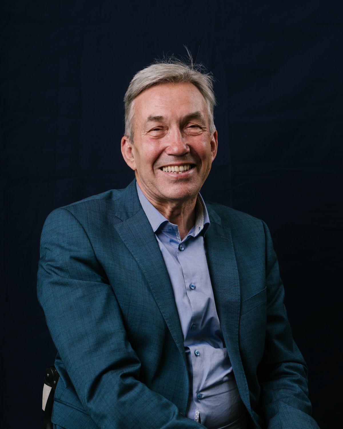 A portrait picture of Nick Webborn, UK Sport Chair, he smiles at the camera in a blue suit.