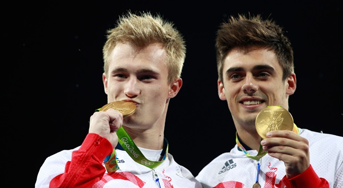 Two divers athletes holding their gold medals