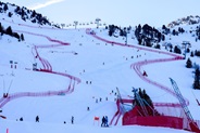 Copilot said:  Snow-covered ski slope with skiers, chairlifts and red safety fencing on a mountain.