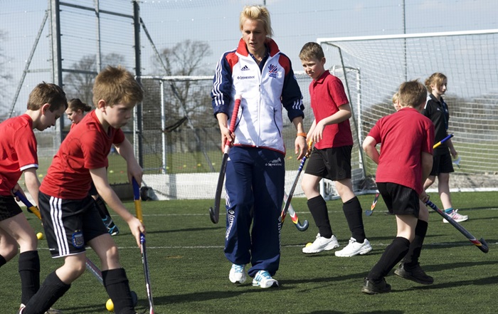 Group of children with coach playing hockey