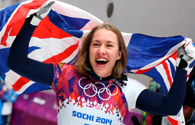 Lizzy Yarnold. A Team GB Skeleton athlete, smiling and celebrating. Waving a union jack flag above her head