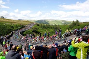 Crowds line the road and take pictures as the peloton of bike riders ride past during the Tour de France 2014 Grand Depart - Stage 1, Leeds to Harrogate - Yorkshire, England - Grinton Moor, Yokshire Dales. 