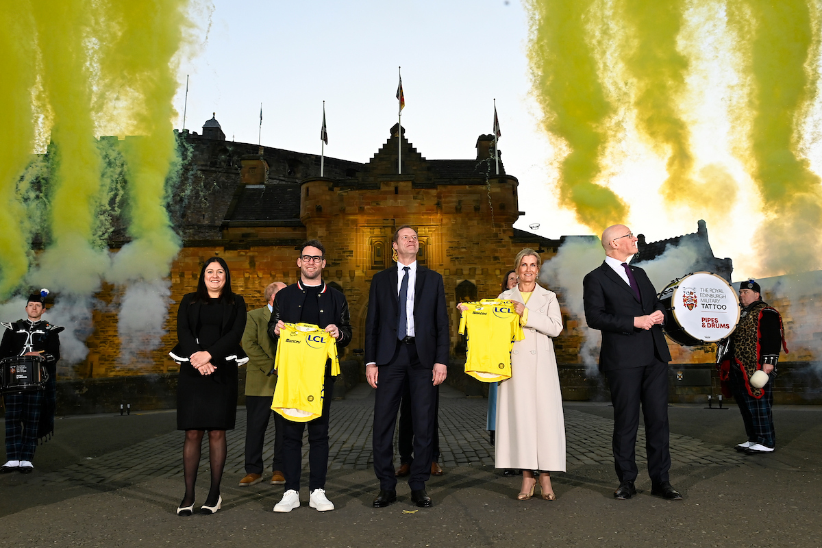 Yellow smoke / fireworks shoots up into the sky in front of Edinburgh Castle, Edinburgh Scotland - The 2027 Tour de France Grand Depart Men will take place in Edinburgh - (L to R) Secretary of State for Culture, Media and Sport Lisa Nandy, Mark Cavendish, Christian Prudhomme, HRH Sophie The Duchess of Edinburgh, First Minister of Scotland John Swinney all in shot under a clear blue sky.