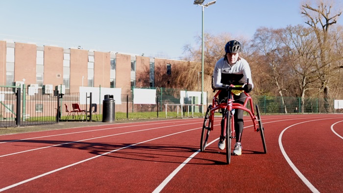 Tully Kearney frame running on a track in Loughborough University in blue sky conditions..
