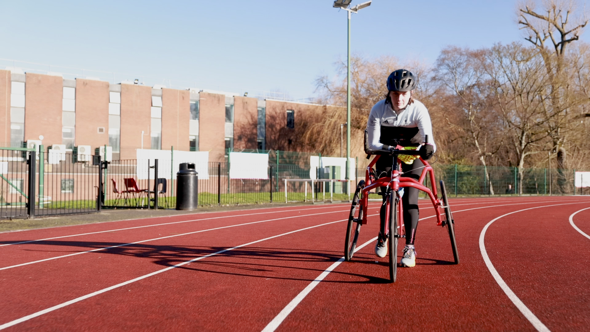 Tully Kearney frame running on a track in Loughborough University in blue sky conditions..